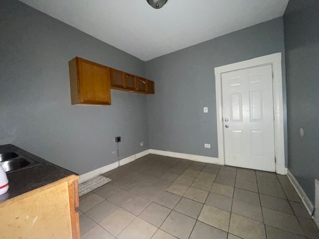 clothes washing area featuring tile patterned flooring, hookup for an electric dryer, and sink