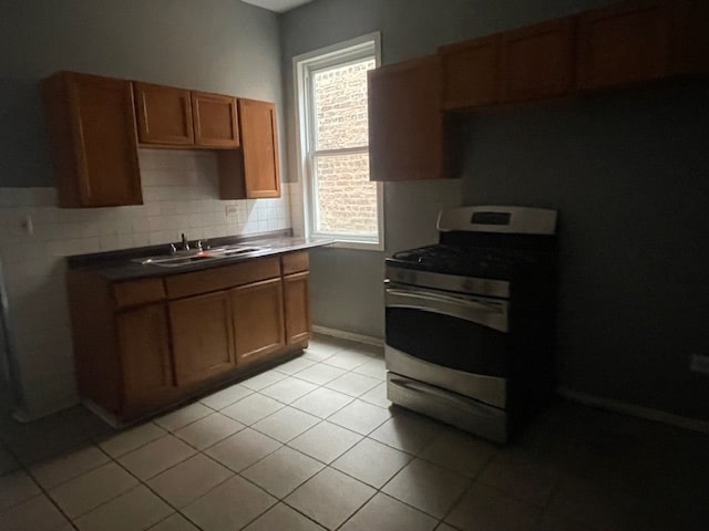 kitchen with white gas stove, plenty of natural light, sink, and tasteful backsplash