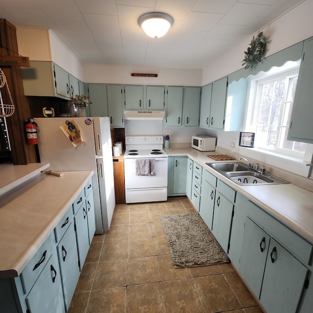 kitchen featuring light tile patterned floors, white appliances, and sink