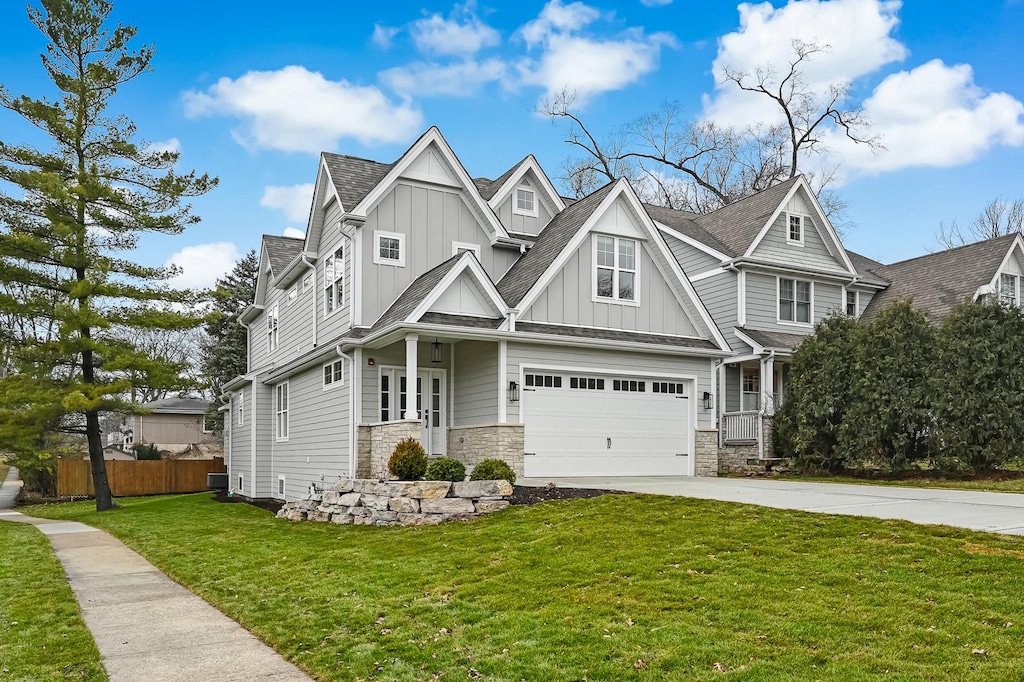 craftsman house featuring central AC, a garage, and a front lawn