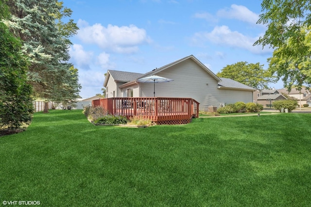 rear view of property featuring a deck and a lawn