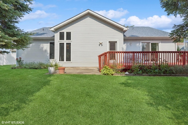 rear view of house featuring a wooden deck and a yard