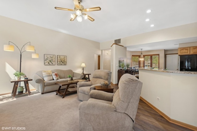 living room with dark hardwood / wood-style flooring and ceiling fan