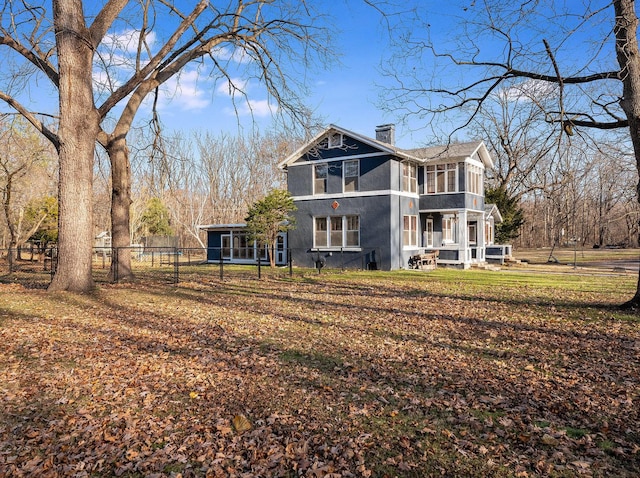 rear view of property featuring a sunroom