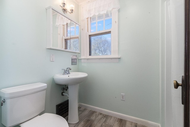 bathroom with hardwood / wood-style flooring, toilet, and sink