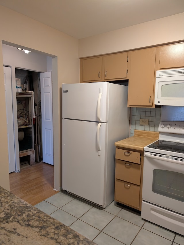 kitchen with light wood-type flooring, white appliances, and backsplash