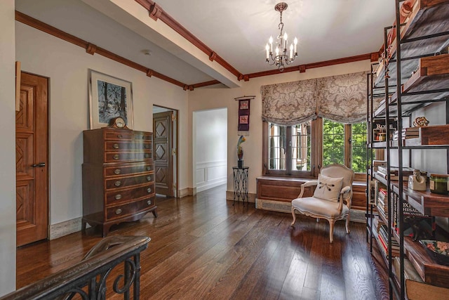 sitting room with dark hardwood / wood-style floors, an inviting chandelier, and ornamental molding