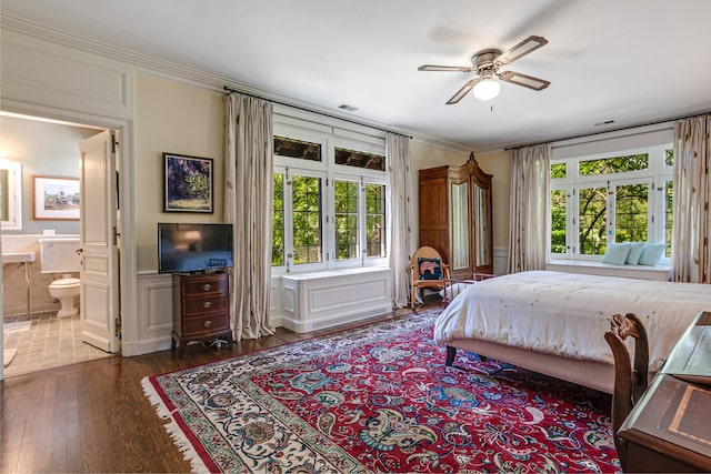 bedroom with connected bathroom, ceiling fan, dark hardwood / wood-style flooring, and ornamental molding