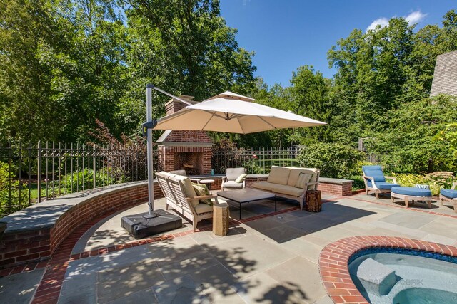 view of patio / terrace with an outdoor living space with a fireplace and a hot tub