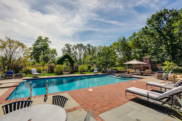 view of swimming pool with exterior fireplace and a patio area