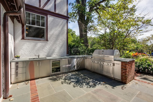 view of patio / terrace with an outdoor kitchen, area for grilling, sink, and wine cooler