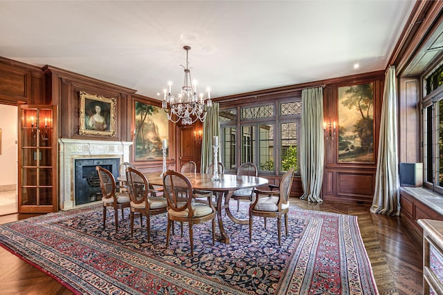 dining area featuring dark parquet flooring, crown molding, and a notable chandelier