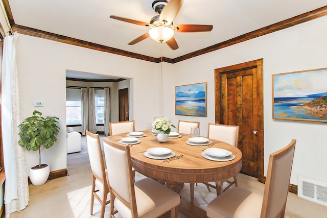 dining space featuring ceiling fan and crown molding