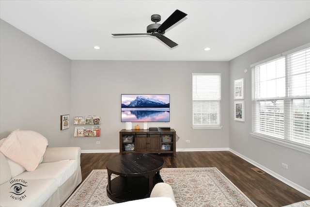 living room with ceiling fan and dark wood-type flooring