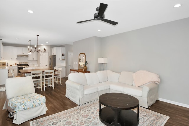 living room featuring dark hardwood / wood-style floors and ceiling fan with notable chandelier