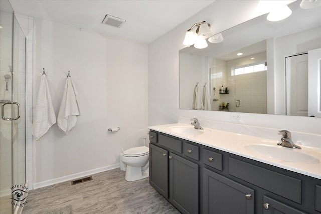 bathroom featuring vanity, toilet, wood-type flooring, and walk in shower