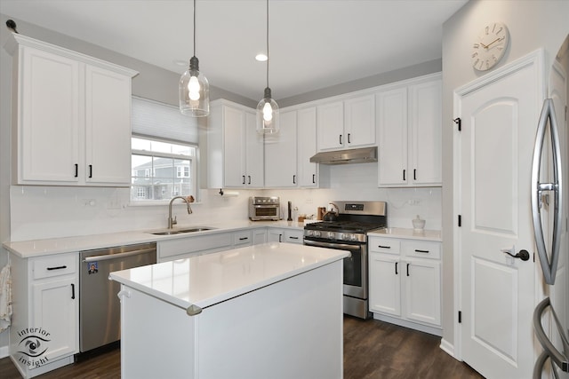 kitchen featuring white cabinets, stainless steel appliances, a kitchen island, and sink