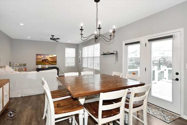 dining area featuring ceiling fan with notable chandelier and dark hardwood / wood-style flooring