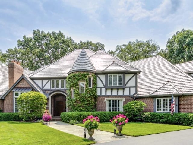 tudor-style house with a front yard