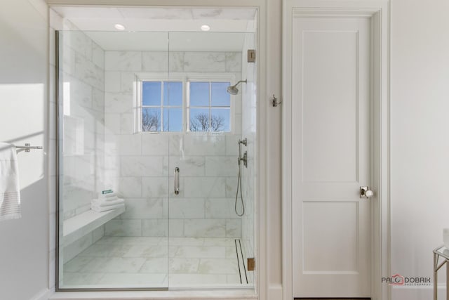 bathroom featuring a shower with door