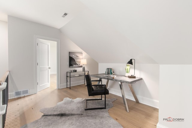 office featuring vaulted ceiling and light hardwood / wood-style floors