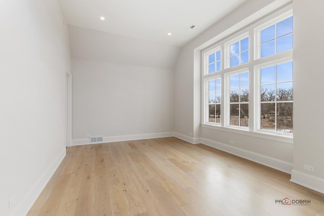 bonus room with lofted ceiling and light wood-type flooring