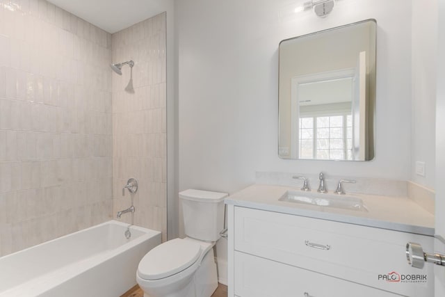 full bathroom with tiled shower / bath, vanity, and toilet