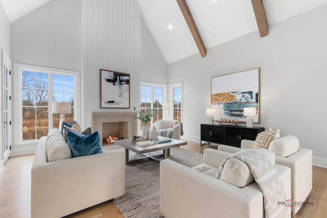 living room with beam ceiling, high vaulted ceiling, and light hardwood / wood-style flooring