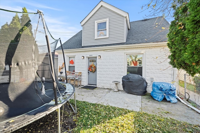 rear view of house with a trampoline