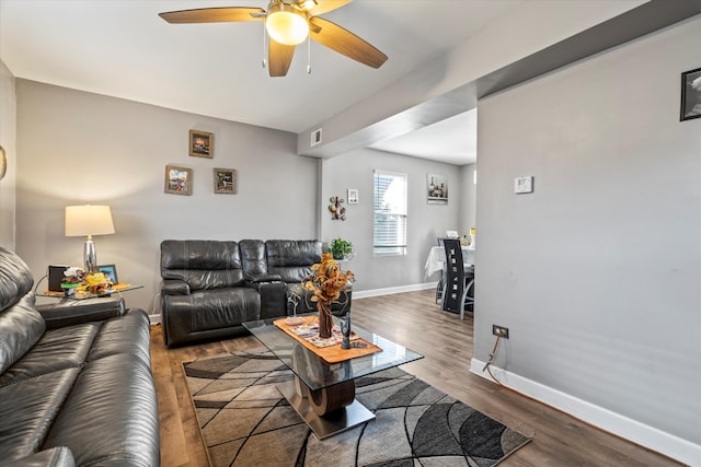 living room featuring dark hardwood / wood-style flooring and ceiling fan