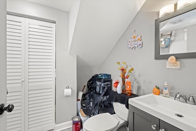 bathroom with vanity, lofted ceiling, and toilet