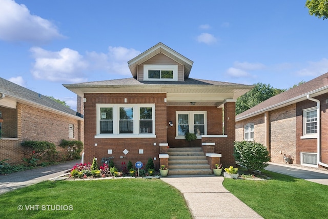 view of front of property featuring covered porch and a front lawn