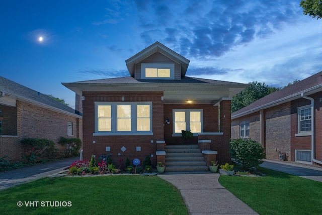 bungalow featuring covered porch and a lawn