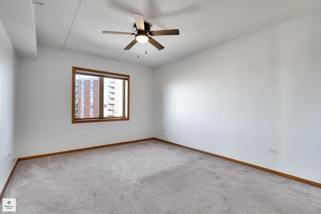 carpeted spare room featuring a textured ceiling and ceiling fan