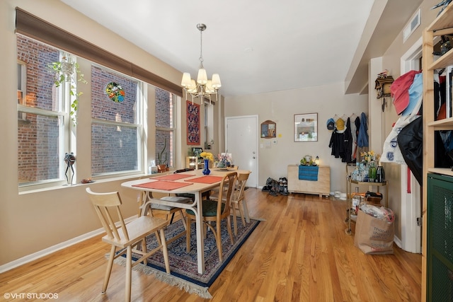 dining room featuring light hardwood / wood-style floors and an inviting chandelier