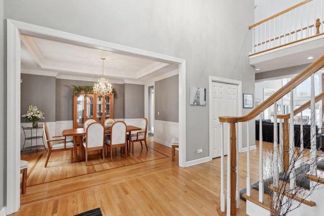 dining area featuring a raised ceiling, plenty of natural light, and light hardwood / wood-style floors