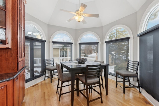 dining room with ceiling fan, lofted ceiling, and light wood-type flooring