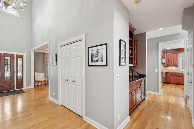 entryway with light hardwood / wood-style flooring and a high ceiling