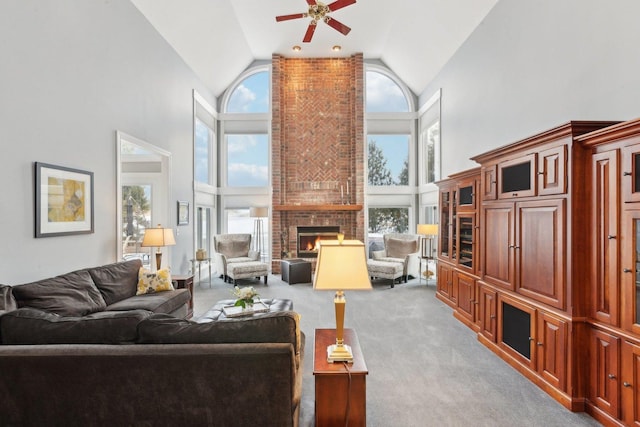 carpeted living room featuring ceiling fan, a fireplace, and high vaulted ceiling