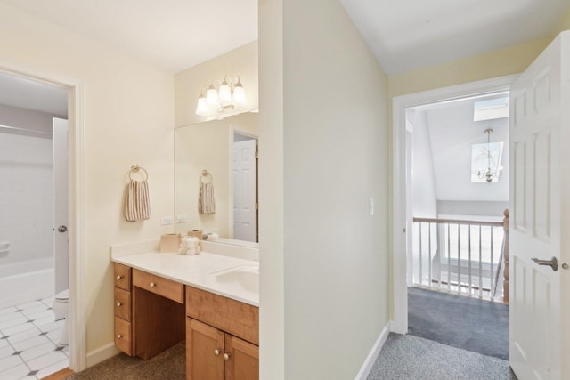 bathroom with a notable chandelier, lofted ceiling, toilet, vanity, and a tub