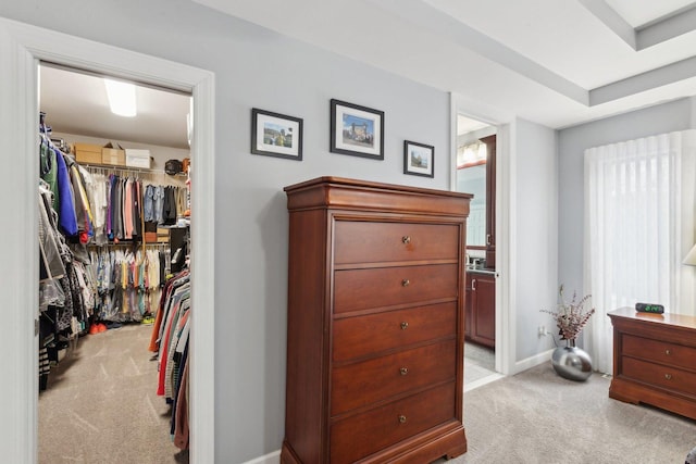 carpeted bedroom with a walk in closet, a closet, and ensuite bathroom