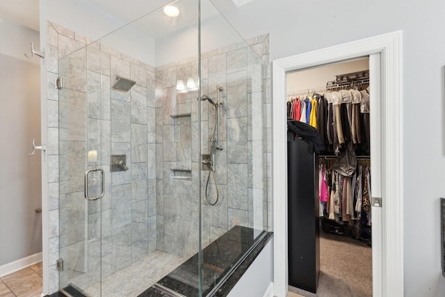 bathroom with an enclosed shower and tile patterned flooring