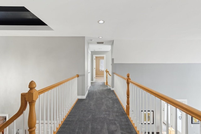 hallway with dark colored carpet