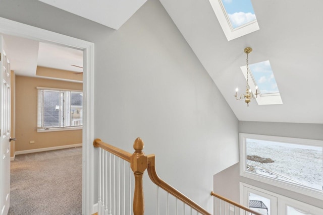 interior space featuring carpet flooring, a wealth of natural light, an inviting chandelier, and a skylight