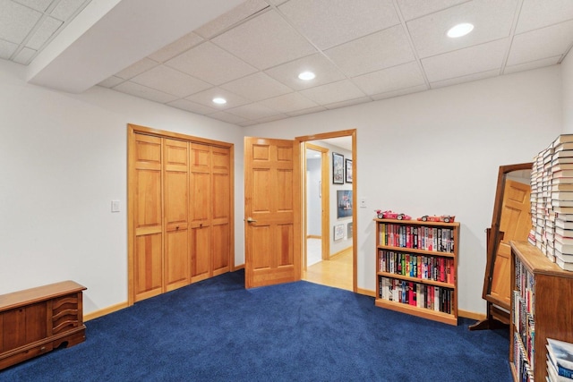 bedroom with carpet, a drop ceiling, and a closet