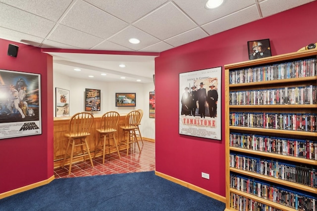 interior space with a paneled ceiling and carpet