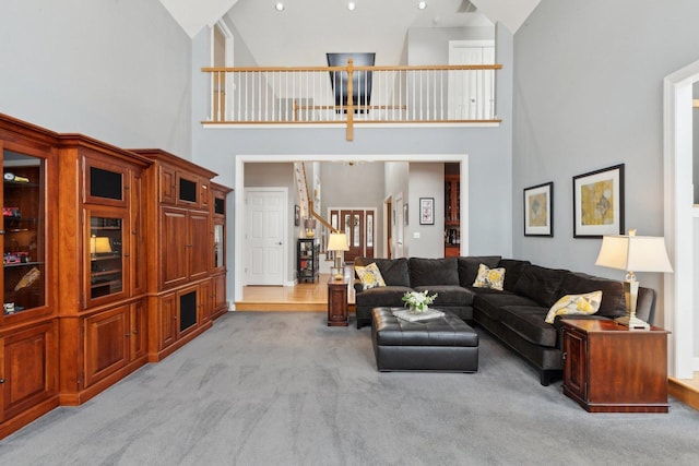 carpeted living room with high vaulted ceiling