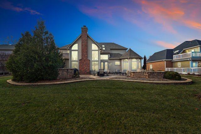 back house at dusk featuring a yard