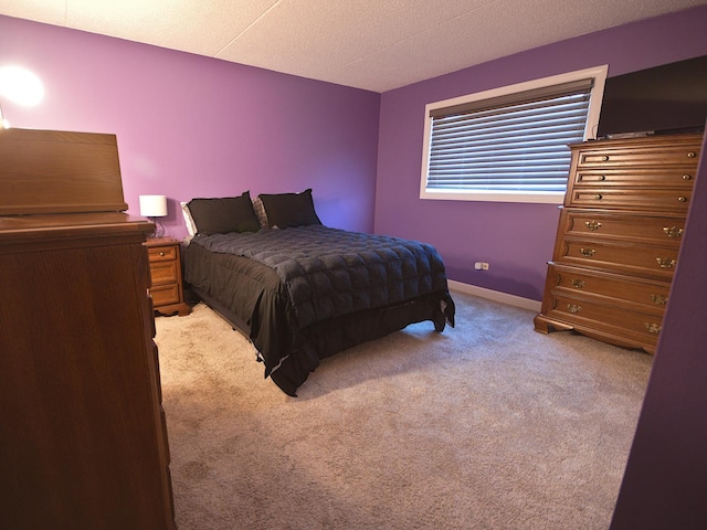 bedroom featuring a textured ceiling and light carpet