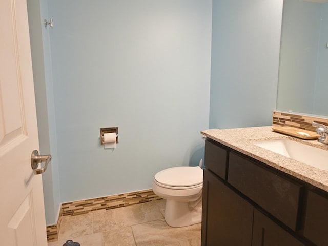 bathroom with vanity, tasteful backsplash, and toilet